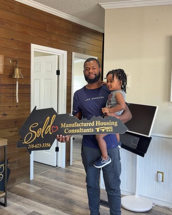 Joshua Jackson holding the MHC sold key with his child at the Von Ormy store