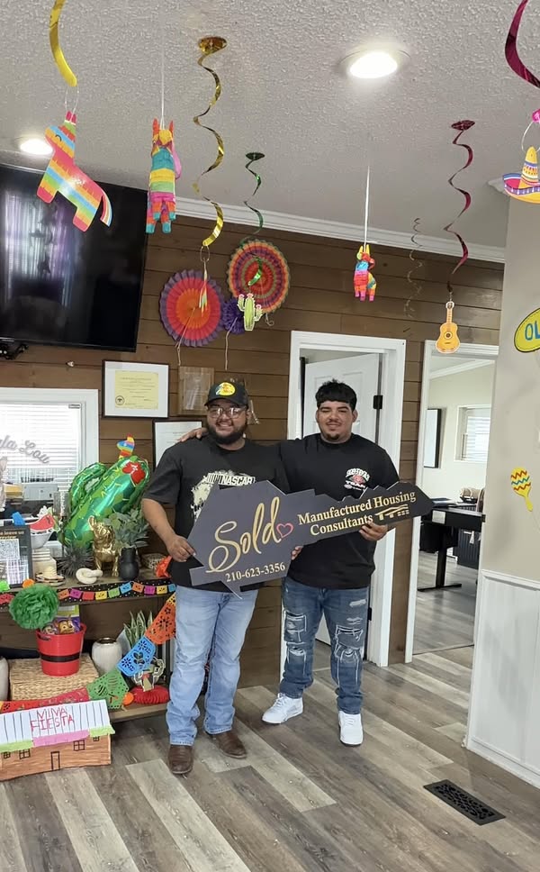 Victor and Carlos Torres holding an MHC sold key at the Von Ormy store