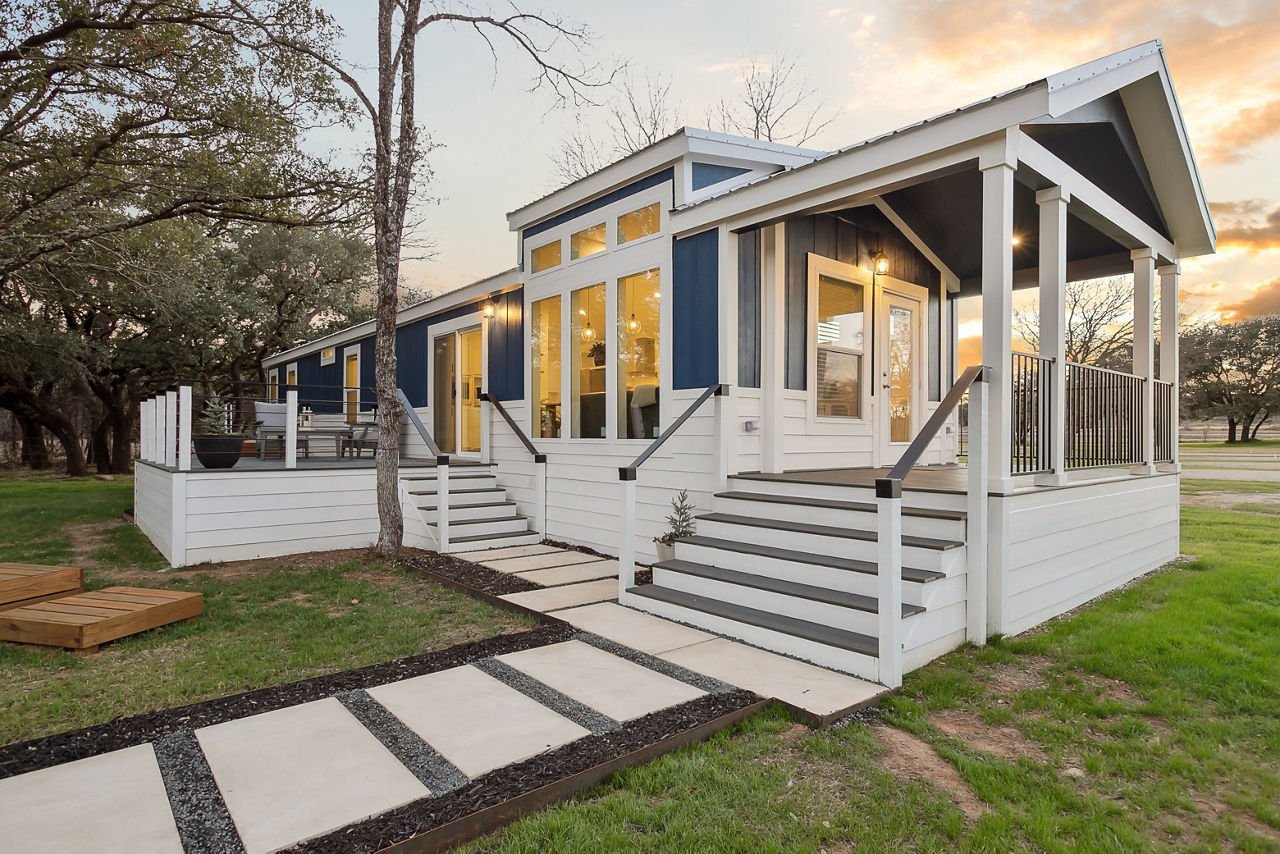 Blue and white manufactured home with a welcoming front porch